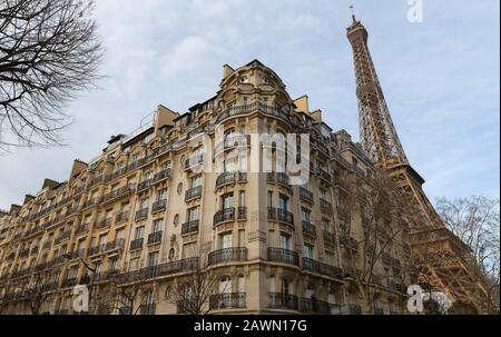 Traditionelle französische Haus mit typischen Balkonen und Fenstern und dem Eiffel Turm im Hintergrund. Paris. Stockfoto