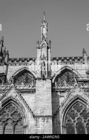 Kleiner Mittelalterturm mit Figur und Wasserspeier an der Südseite des York Minster. Auf jeder Seite befinden sich Fenster und darüber ein Himmel. Stockfoto