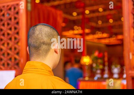 Hongkong, China - 11. Dezember 2016: Mönch in Orange von hinten im Po Lin Kloster des großen Buddha, Symbol der Insel Lantau, Chinesisch Stockfoto