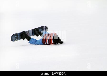 Weitwinkel-Aufnahme eines Mannes auf Schnee gefallen mit Ein Skateboard Stockfoto