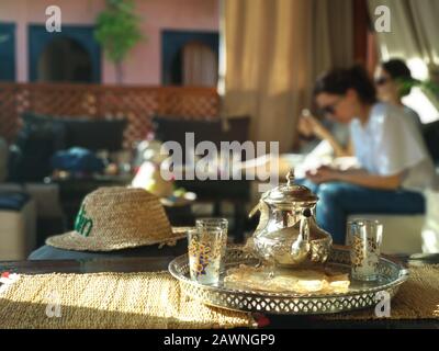 Selektive Fokusaufnahme eines Wasserkochers und Gläser für traditionelle Marokkanischer Tee mit Minze in einem Café Stockfoto