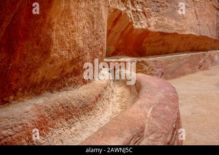 In Felsritzungen in der Nähe des nabatäischen Aquädukts durch die enge Schlucht des Siq Canyon, der Hauptzugang zur antiken Stadt Petra, Jordanien ist Stockfoto