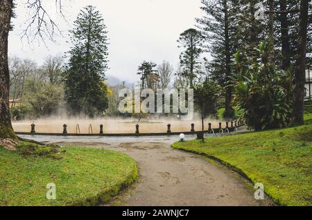 Furnas, Azoren, Portugal - 13. Januar 2020: Thermalbad mit heißem Quelleisen im Terra Nostra Garden. Der Pool ist von einem grünen botanischen Garten umgeben. Portugiesische Touristenattraktion. Stockfoto