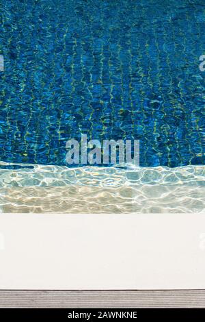 Schwimmbad mit blauen Fliesen und gewelltem Wasser. Abstraktes Vollbildbild. Stockfoto