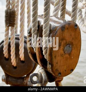 Ein Holzklotz und ein Angriff auf eine historische Segelschlaufe. Stockfoto