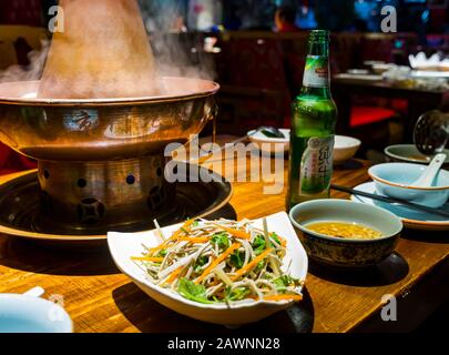 Mongolischer Hotspot wird im Restaurant mit lokalem Tsingtao-Bier, Xi Cheng Hutong District, Peking, China, Asien serviert Stockfoto