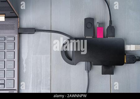USB-Adapter Typ C oder Hub, der mit verschiedenen Zubehörteilen an den Laptop angeschlossen ist - Pendreifen, hdmi, ethernet, Speicherkarte, Kabel. Flacher Lay Draufsicht. Stockfoto