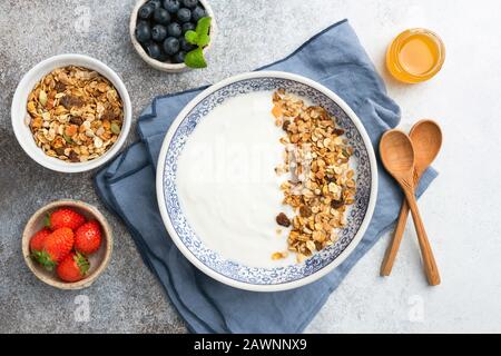 Joghurt mit Honiggranola in der Schüssel, Platz für Designelemente oder Text. Gesundes Frühstück, sauberes Esskonzept Stockfoto
