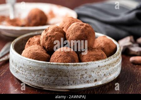 Schokoladentrüffel auf dem Teller. Hausgemachte Schokoladentrüffel, Schokoladenbonbon in Kakaopulver gewalzt Stockfoto