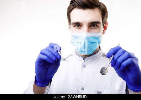 Brunet Male Dentist in Maske Mit Spiegel und Sonde Stockfoto