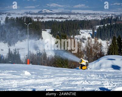 Schneemaschine, auch Schneekanone oder Schneekanone im Einsatz genannt Stockfoto