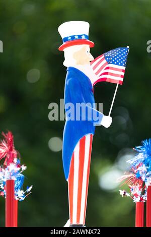 Arlington, Texas, USA - 4. Juli 2019: Arlington, 4. Juli Parade, Kleine Zierde in Form des Onkels sam, die Nationalflaggen während der Par hält Stockfoto