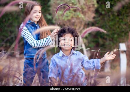 Zwei glückliche Kinder, verschiedene Rennjungen und Mädchen, die im Freien spielen. Konzept für Kindheit und Emotionen. Stockfoto