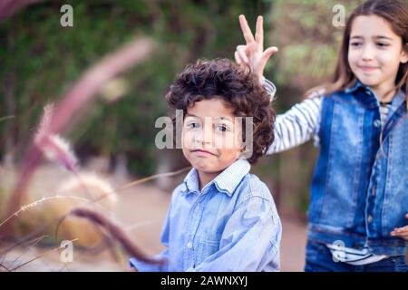 Zwei glückliche Kinder, verschiedene Rennjungen und Mädchen, die im Freien spielen. Konzept für Kindheit und Emotionen. Stockfoto