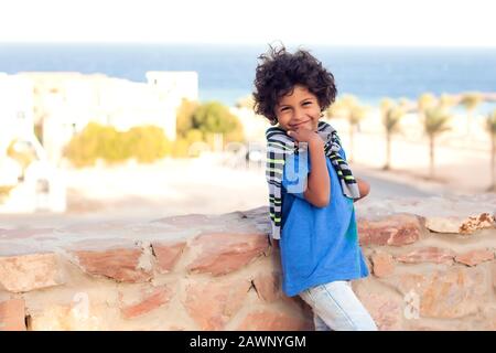 Ein Porträt eines lächelnden Jungen im Freien in blauem T-Shirt. Konzept für Kinder und Emotionen Stockfoto