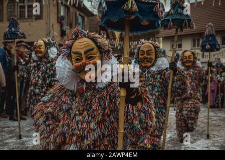 Barcelona, Spanien. Februar 2020. Verkleidete Narren tragen traditionelle Holzmasken der 'Swabian-alemmannischen Fastnacht', wie sie während der großen Narrenprozession durch Eigeltingen marschieren. Credit: Matthias Oesterle/Alamy Live News Stockfoto