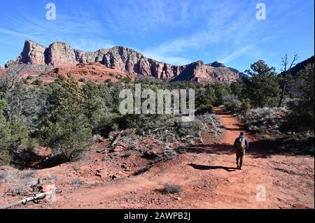 Sedona, Arizona - 25. Januar 2020 - Junger männlicher Wanderer auf dem Wanderweg im roten Felsland in der Nähe von Sedona, Arizona am klaren Wintermorgen. Stockfoto