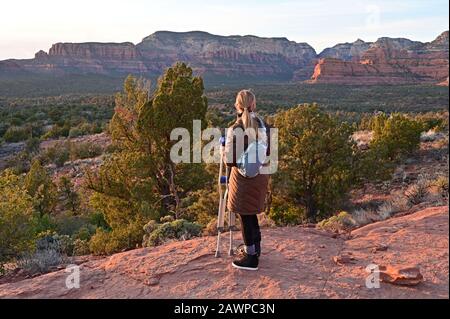 Sedona, Arizona - 25. Januar 2020 - Frau, die Krücken hält, genießt auf Jeep-Tour einen Blick auf den Sonnenuntergang im Backcountry. Stockfoto