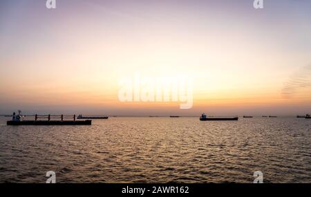 Frachtschiffe bei Sonnenuntergang ankerten vor Buenos Aries und warteten darauf, Fracht zu laden. Stockfoto