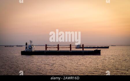 Frachtschiffe bei Sonnenuntergang ankerten vor Buenos Aries und warteten darauf, Fracht zu laden. Stockfoto