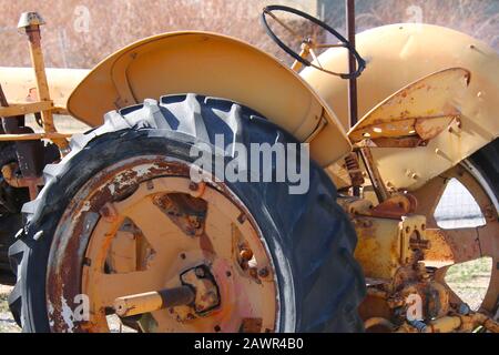Ein verrosteter, gelber, alter Bauernschlepper Stockfoto