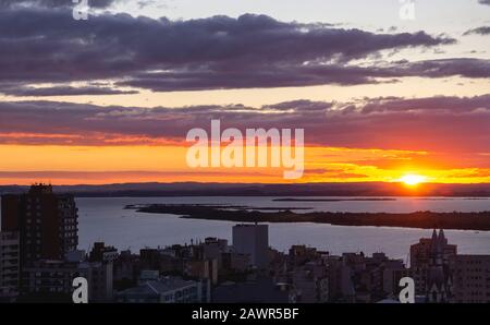 Wolkiger Himmel und Sonnenuntergang über dem Guaiba See in Porto Alegre, Brasilien Stockfoto