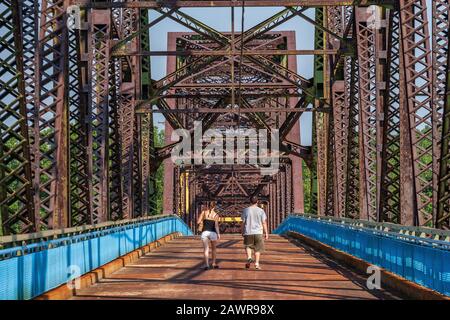 Zwei Personen, die auf der Old Chain of Rocks Bridge, der ehemaligen Route 66 über den Mississippi River, spazieren gehen Stockfoto