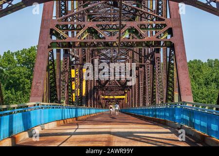 Zwei Personen, die auf der Old Chain of Rocks Bridge, der ehemaligen Route 66 über den Mississippi River, spazieren gehen Stockfoto