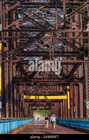 Zwei Personen, die auf der Old Chain of Rocks Bridge, der ehemaligen Route 66 über den Mississippi River, spazieren gehen Stockfoto