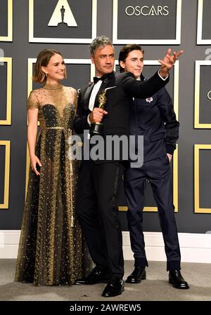 Natalie Portman und Timothee Chalamet präsentieren Taika Waititi mit seinem Besten Angepassten Drehbuch für Jojo Rabbit im Presseraum bei der 92. Oscarverleihung im Dolby Theatre in Hollywood, Los Angeles, USA. Stockfoto