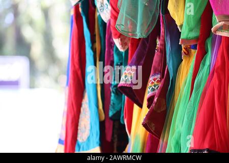 Nahaufnahme von weiblichen Tüchern mit vielen Farben, die an Straßenlappen hängen, Geschäft auf dem indischen Markt für Tücher, Markt für Straßenlappen Stockfoto