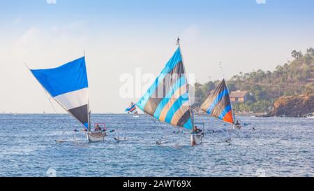 Fischer in traditionellen Segel-Jukungs (ausgetroffene Kanus) kehren mit ihrem Fang nach Ahmed Beach in Bali, Indonesien zurück. Stockfoto