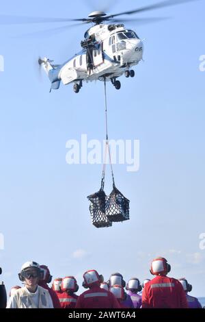 Philippinisches MEER (Feb. 03, 2020) Eine Aerospatiale SA 330J Puma vom Trockenfracht- und Munitionsschiff USNS Richard E. Byrd (T-AKE 4) liefert während eines vertikalen Nachschubs auf See Fracht an Bord des Docklandungsschiffs USS Germantown (LSD 42) der Whidbey-Island-Klasse. Germantown, Teil der America Expeditionary Strike Group, 31. Marine Expeditionary Unit Team, ist im 7. US-Flottengebiet tätig, um die Interoperabilität mit Verbündeten und Partnern zu verbessern und dient als einsatzbereite Einsatzkräfte zur Verteidigung von Frieden und Stabilität in der Region Indopazifik. (USA Navy-Foto von Mass Communication Specia Stockfoto