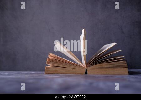 Offenes Buch über schwarzen Hintergrund, Bildung und Klugheitskonzept Stockfoto
