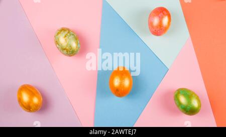 Modernes minimalistisches osterlayout mit Eiern auf farbenfrohem geometrischem Hintergrund. Stockfoto