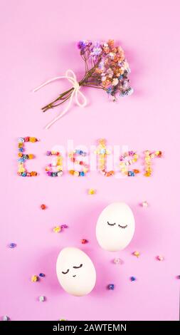 Osterkreatives Layout mit dem Wort Ostern aus Blumen, einem Blumenstrauß aus kleinen Blumen und niedlichen weißen Eiern mit geschlossenen Augen auf dem Flieder. Stockfoto