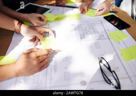 Team von Ingenieuren, die bei der Arbeit an Bauvorhaben Ideen auf Aufklebern schreiben Stockfoto