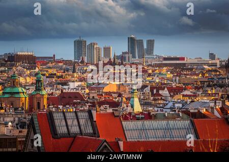 Prag, Tschechien - Blick Auf Die Skyline Von Prag bei Sonnenuntergang im Winter mit roten Dächern, bewölktem Himmel und Wolkenkratzern im Geschäftsviertel Stockfoto