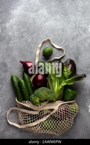 Frisches Gemüse und Obst in einem Saitenbeutel auf Betongrund. Das Konzept des Umweltschutzes und der gesunden Ernährung, Draufsicht Stockfoto