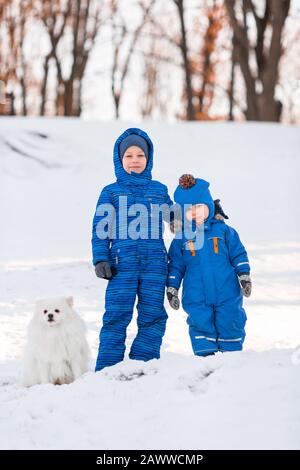 Kleine Jungen mit Spitzhund im Winter im Park Stockfoto