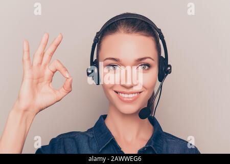 Fröhlicher junger Agent des Callcenters, der "OK" gestikuliert hat Stockfoto