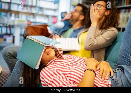 Hochschulkonzept, Studium, Hochschule und Bildungskonzept. Gruppe von müden Schülern, die in der Bibliothek lernen Stockfoto