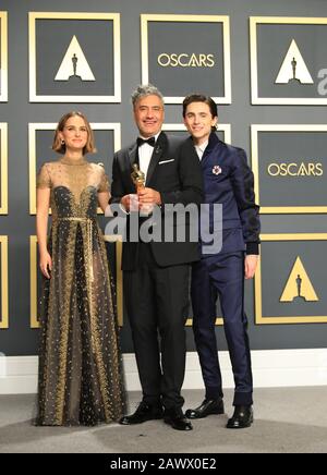 Los Angeles, USA. Februar 2020. Die Moderatoren Natalie Portman (L) und Timothee Chalamet (R) posieren für Fotos mit Taika Waititi, Gewinner des Preises für das beste adaptierte Drehbuch für "Jojo Rabbit", bei der 92. Oscarverleihung im Dolby Theatre in Los Angeles, den Vereinigten Staaten, 9. Februar 2020. Kredit: Li Ying/Xinhua/Alamy Live News Stockfoto