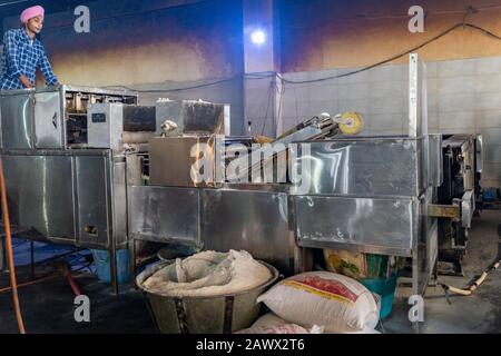 Amritsar Indien - Februar 8, 2020: Sikh man beobachtet, wie seine automatische Maschine Chapati zubereitet - traditionelles indisches Brot im Goldenen Tempel (sri harmandi Stockfoto