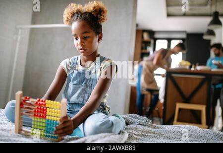 Happy afrikanischen amerikanischen Jungen Mädchen lernen zu Hause mit Abacus zu zählen Stockfoto