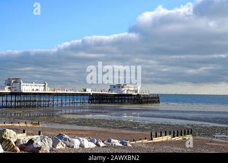 Worthing Pier und Strand mit dem Windpark Rampion am Horizont, an einem sonnigen Wintertag Sussex England UK Stockfoto