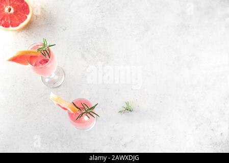 Mimosa-Cocktail mit Champagner, Grapefruit und Rosemary in Flötenbrille, Draufsicht, Kopierraum. Mocktail, Mimosa Sekt Zitrusprink. Stockfoto