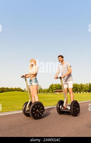 Junges, glückliches Touristenpaar, das gerne segway fährt Stockfoto