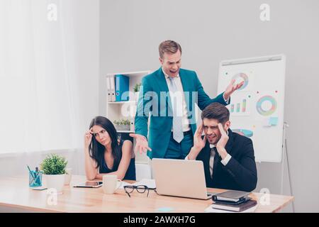 Wütend frustrierter Chef schreit seine Arbeiter wegen schlechten Plans an Stockfoto