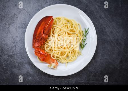 Spaghetti Meeresfrüchte Hummer Speisen auf einem weißen Teller / Spaghetti Abendessen mit Rosmarin serviert Tisch im Restaurant Gourmet-Essen gesunde Hummerkralle Krabben Stockfoto